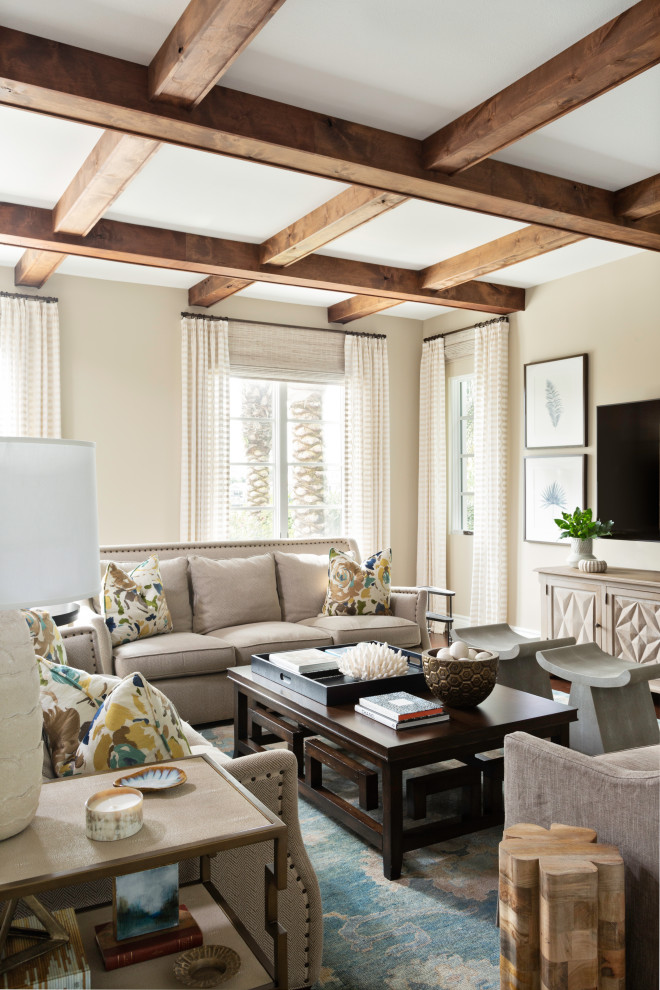 Großes Mediterranes Wohnzimmer mit beiger Wandfarbe, braunem Holzboden, TV-Wand, braunem Boden und freigelegten Dachbalken in Tampa
