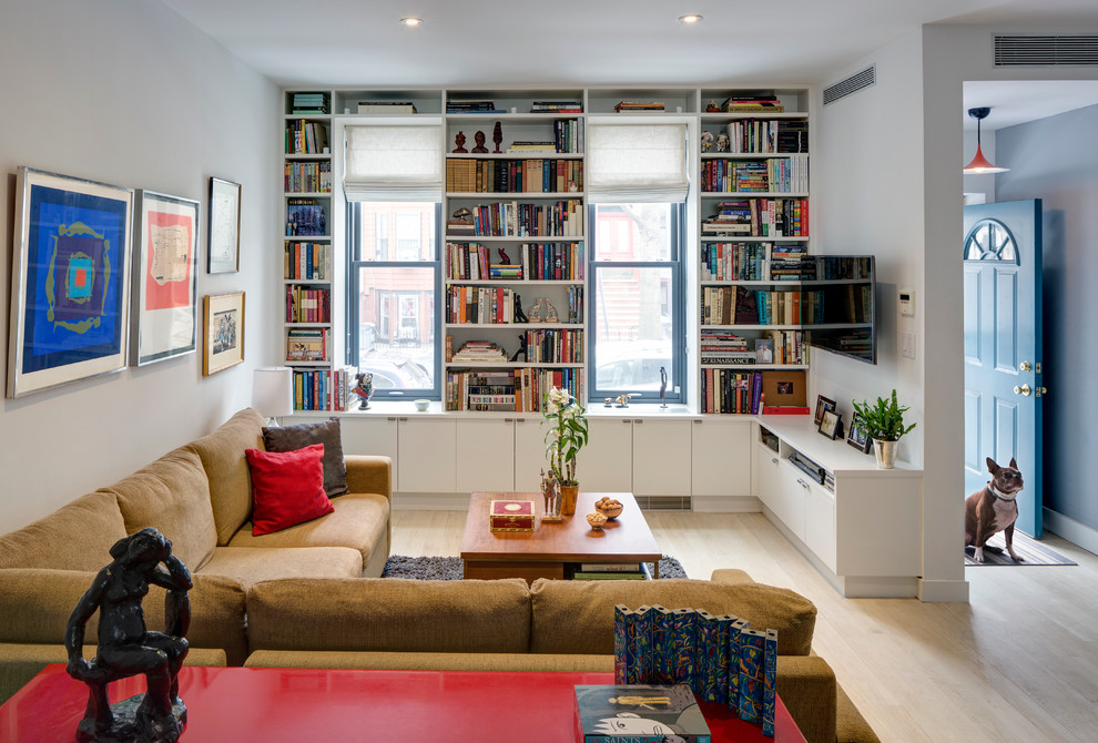 Esempio di un soggiorno contemporaneo con libreria, pareti bianche, parquet chiaro e TV a parete