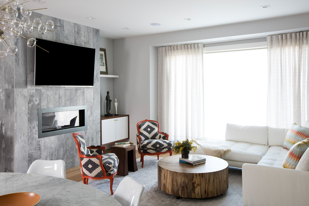 На фото: парадная, открытая гостиная комната среднего размера в стиле модернизм с серыми стенами, паркетным полом среднего тона, горизонтальным камином, фасадом камина из бетона, телевизором на стене и коричневым полом с