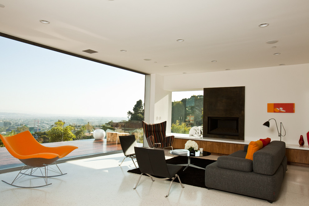 На фото: большая открытая гостиная комната в стиле ретро с белыми стенами и фасадом камина из металла без телевизора, камина
