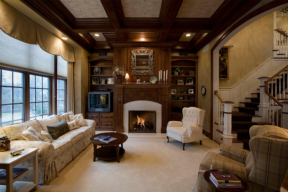 Idée de décoration pour un grand salon tradition avec un manteau de cheminée en bois, une bibliothèque ou un coin lecture, une cheminée standard, un mur marron, moquette, aucun téléviseur et un sol beige.