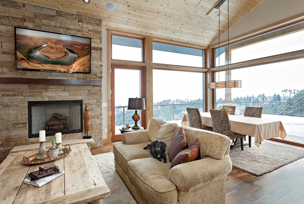 Exemple d'un salon montagne ouvert avec une salle de réception, un mur beige, un sol en bois brun, une cheminée standard, un manteau de cheminée en brique et aucun téléviseur.