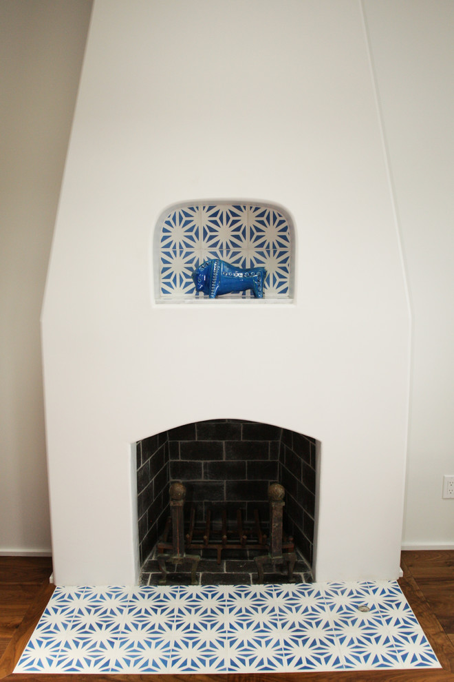 Cette image montre un salon design avec un mur blanc, parquet foncé, une cheminée standard et un manteau de cheminée en carrelage.