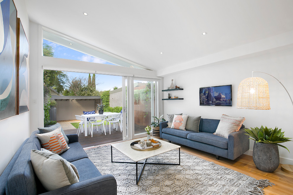 Offenes Modernes Wohnzimmer ohne Kamin mit braunem Holzboden, TV-Wand und braunem Boden in Sydney