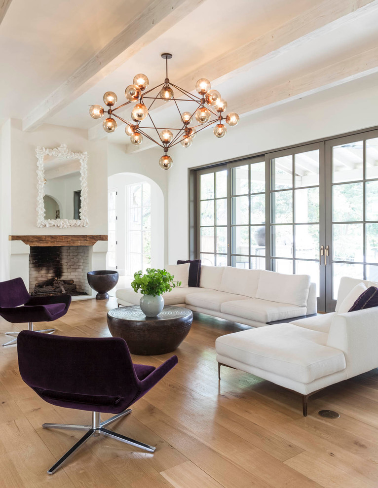 Klassisches Wohnzimmer mit weißer Wandfarbe, hellem Holzboden, Kamin und Kaminumrandung aus Backstein in Dallas