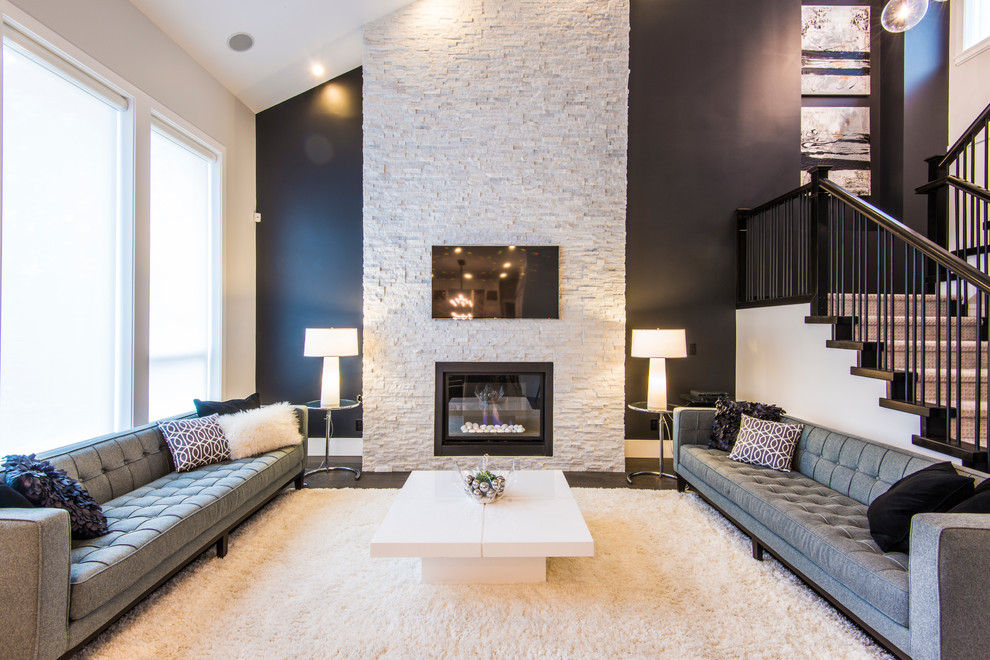 Inspiration for a contemporary living room in Vancouver with a stone fireplace surround and feature lighting.