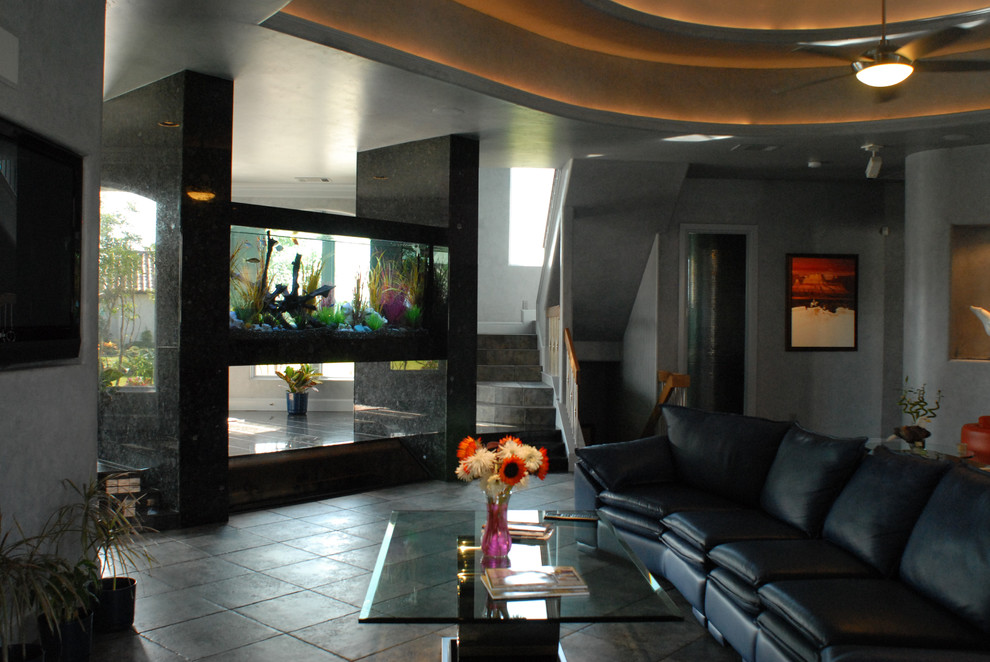 На фото: большая открытая, парадная гостиная комната в современном стиле с серыми стенами, бетонным полом, серым полом и мультимедийным центром без камина