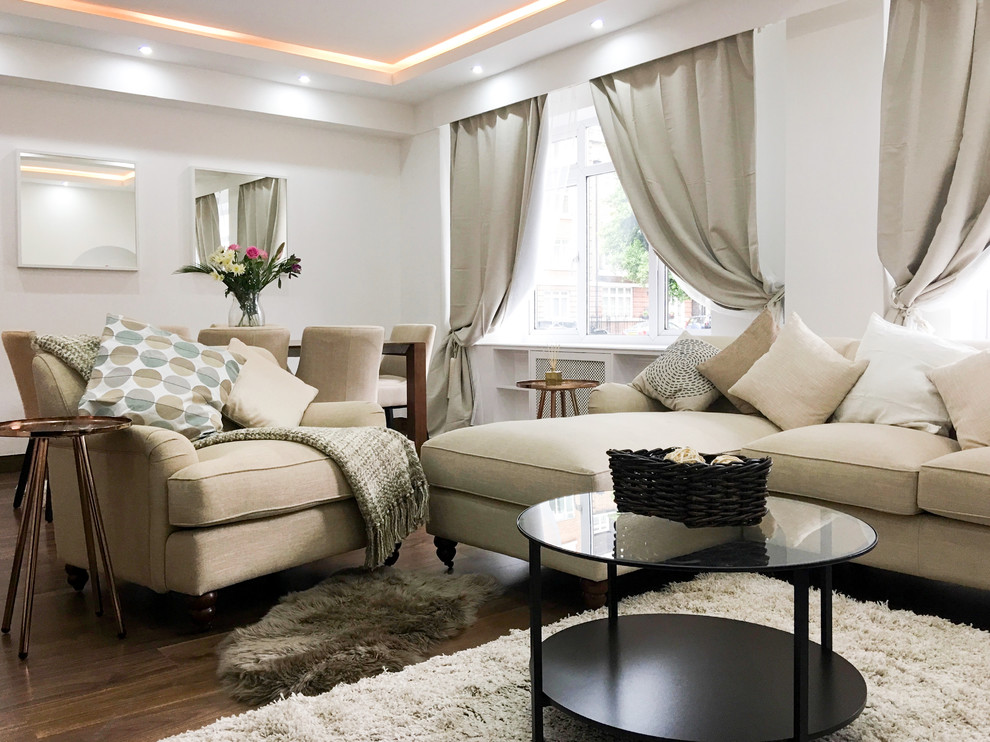 Immagine di un grande soggiorno classico con pareti bianche, pavimento in legno massello medio, camino classico e cornice del camino in pietra