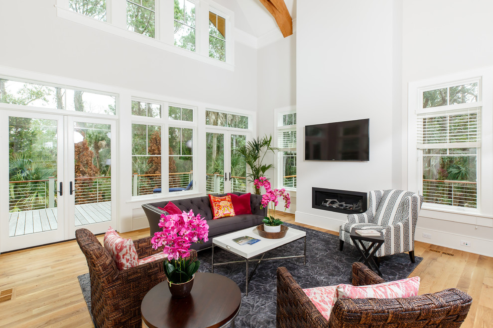 Mittelgroßes, Offenes Maritimes Wohnzimmer mit weißer Wandfarbe, braunem Holzboden, Gaskamin, TV-Wand und braunem Boden in Charleston
