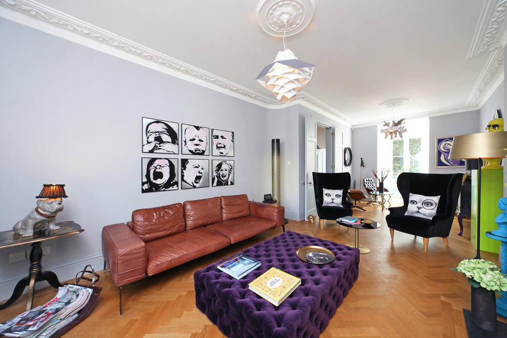 This is an example of a contemporary open plan living room in London with grey walls and medium hardwood flooring.