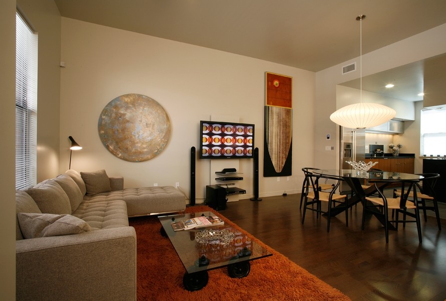 Immagine di un soggiorno moderno di medie dimensioni e aperto con pareti beige, TV a parete e pavimento in legno massello medio