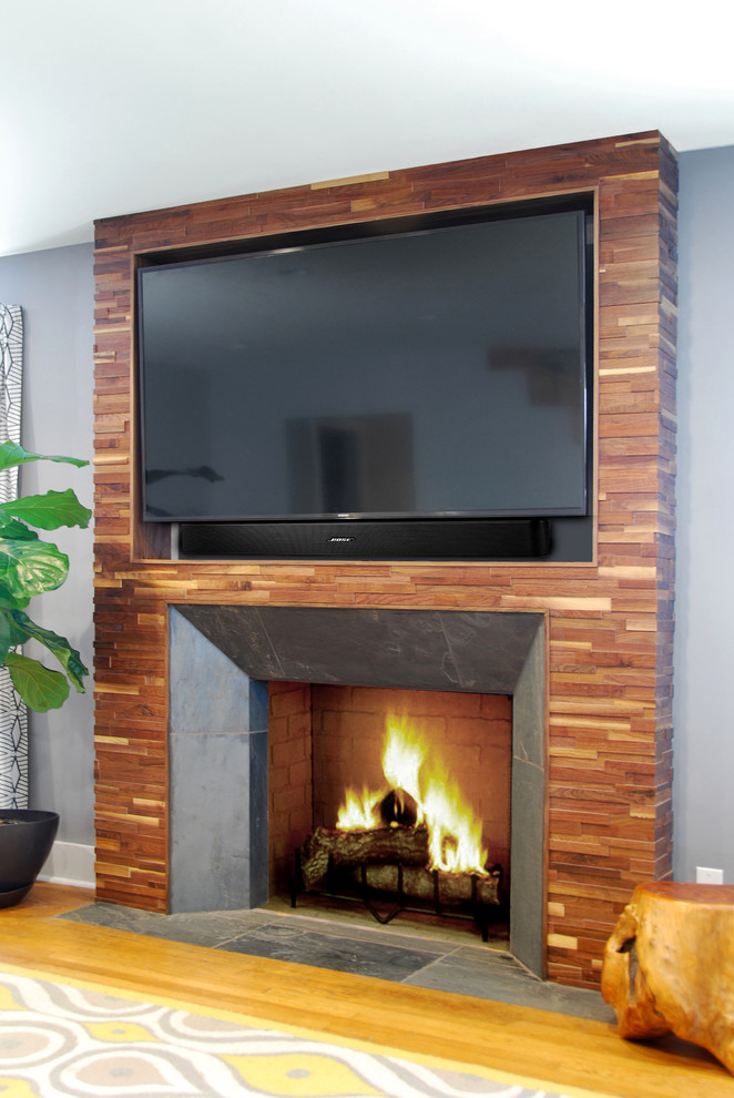 Idee per un soggiorno moderno di medie dimensioni con pareti grigie, pavimento in legno massello medio e TV a parete