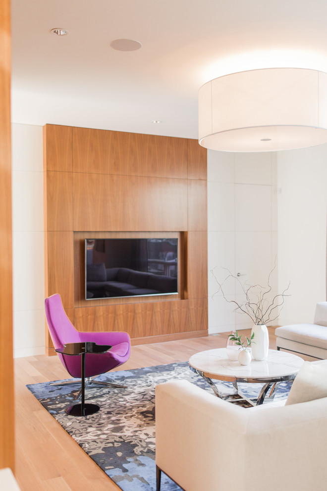 Diseño de salón abierto contemporáneo grande con paredes blancas, suelo de madera en tonos medios y televisor colgado en la pared