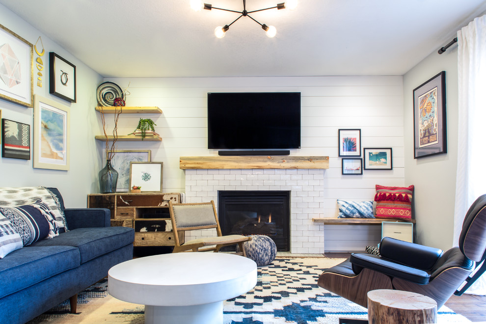 На фото: маленькая парадная, изолированная гостиная комната в стиле фьюжн с белыми стенами, ковровым покрытием, стандартным камином, фасадом камина из плитки, телевизором на стене, разноцветным полом и синим диваном для на участке и в саду с