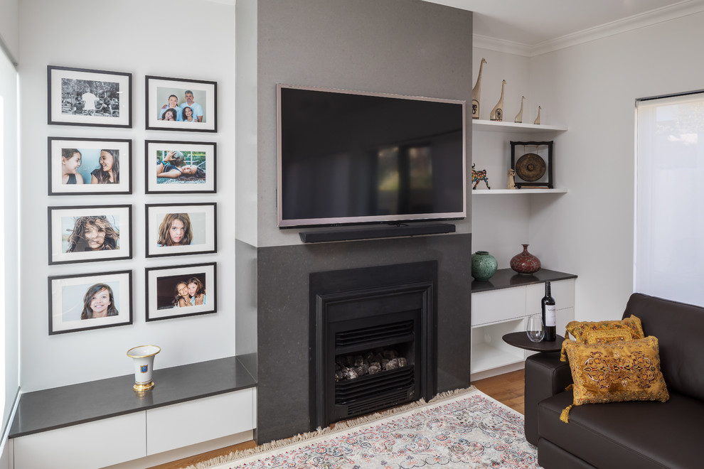 Foto di un soggiorno minimalista con camino classico, cornice del camino in pietra e TV a parete