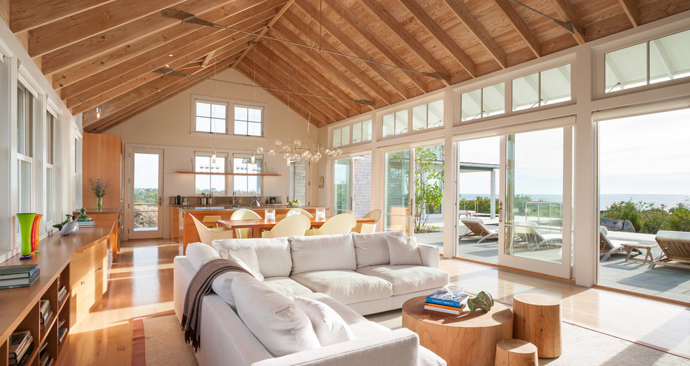 Aménagement d'un salon bord de mer ouvert avec un mur beige et un sol en bois brun.