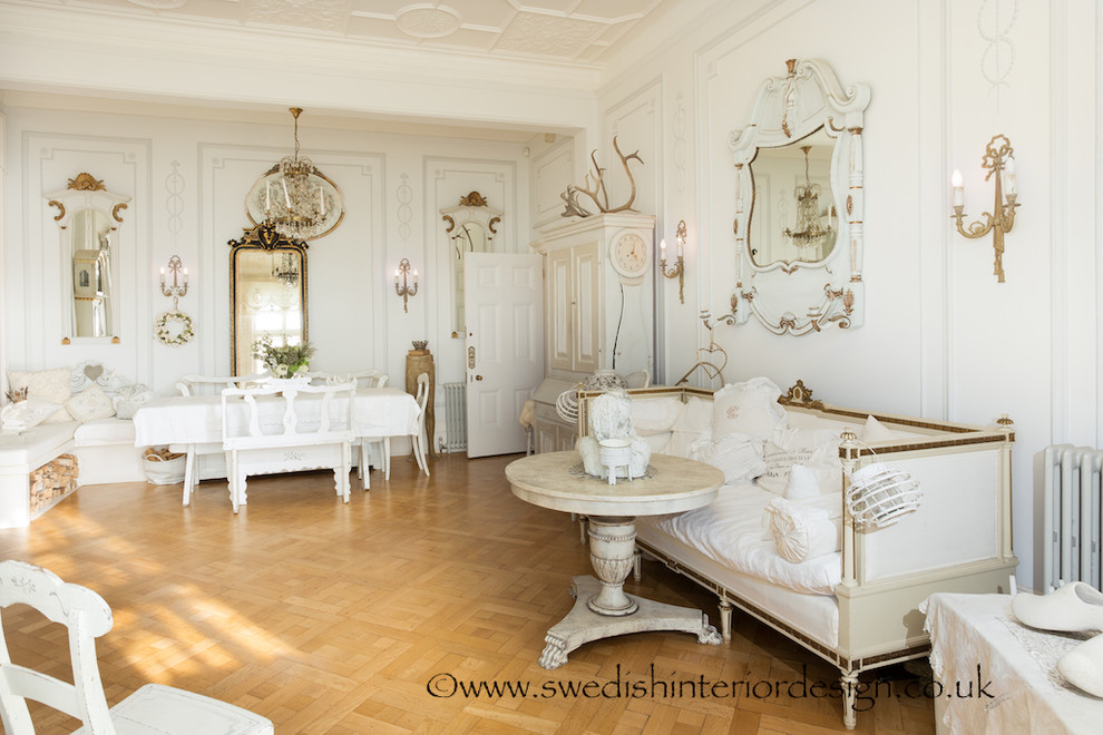 Cette photo montre un très grand salon romantique ouvert avec un mur blanc, parquet clair, une cheminée standard et un manteau de cheminée en pierre.