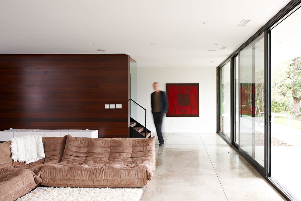 Aménagement d'un salon moderne avec sol en béton ciré et un escalier.