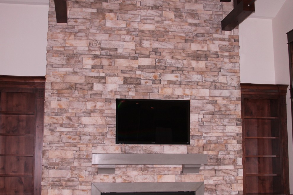 Ejemplo de salón abierto moderno con marco de chimenea de piedra y televisor colgado en la pared