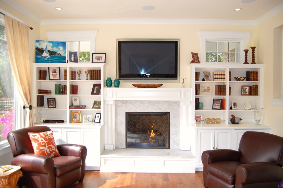 Mittelgroßes, Abgetrenntes Klassisches Wohnzimmer mit beiger Wandfarbe, braunem Holzboden, Kamin, Kaminumrandung aus Stein, TV-Wand und braunem Boden in San Francisco