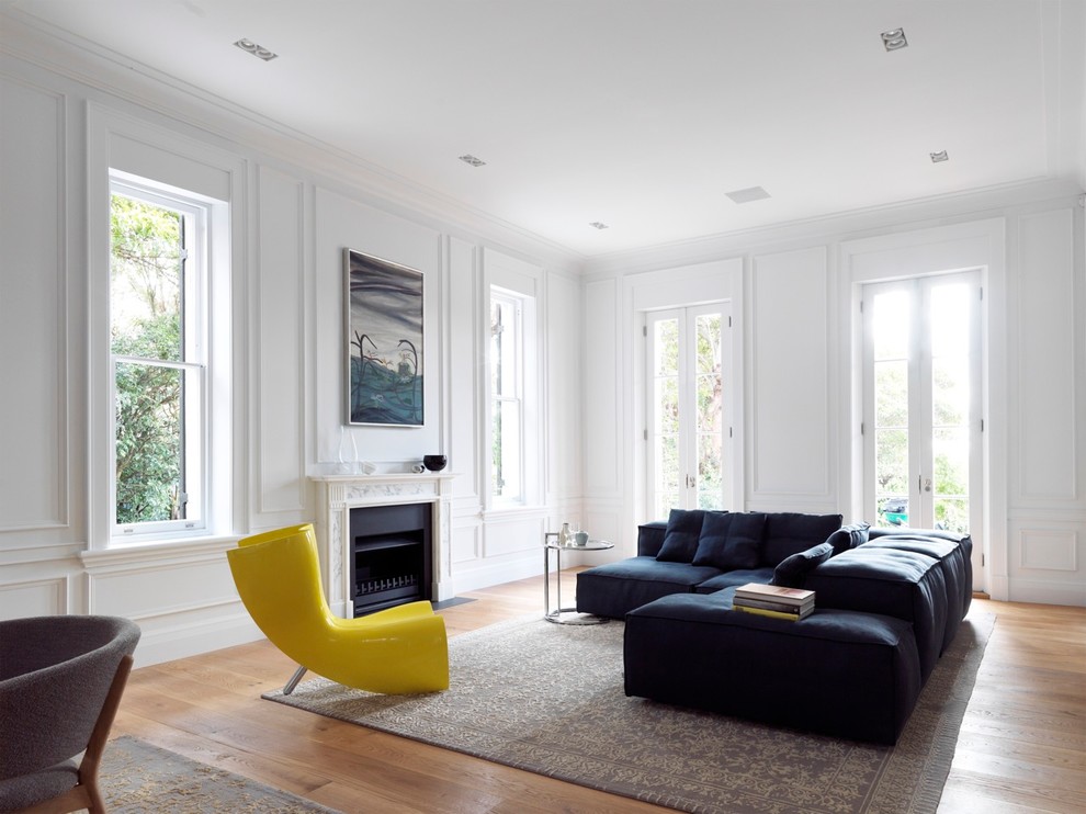 Stilmix Wohnzimmer mit weißer Wandfarbe, braunem Holzboden und Kamin in Sydney