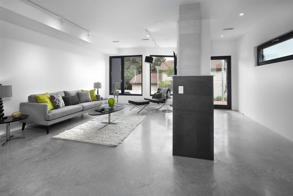 Bild på ett funkis vardagsrum, med vita väggar, betonggolv, en standard öppen spis, en spiselkrans i trä och en väggmonterad TV