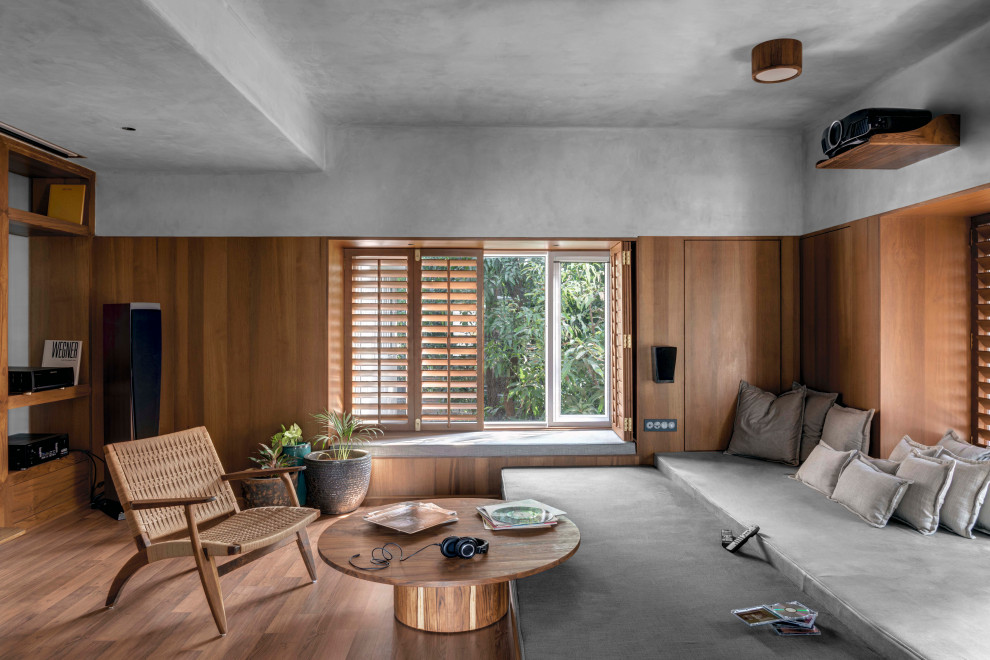 Свежая идея для дизайна: гостиная комната в современном стиле с серыми стенами, паркетным полом среднего тона, коричневым полом и деревянными стенами - отличное фото интерьера
