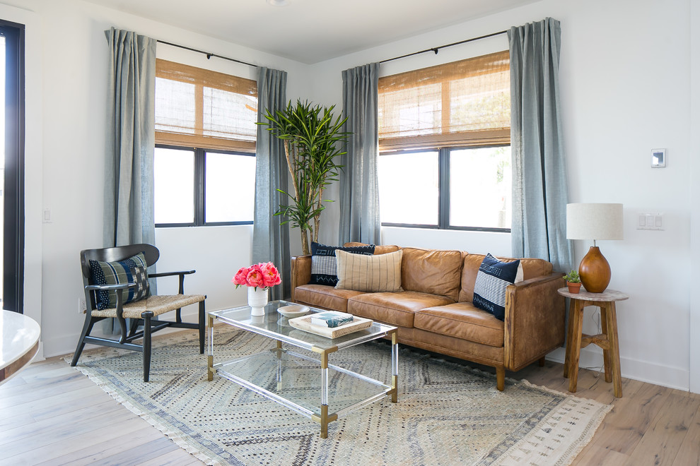 Свежая идея для дизайна: гостиная комната в морском стиле с белыми стенами, паркетным полом среднего тона, коричневым полом и коричневым диваном - отличное фото интерьера