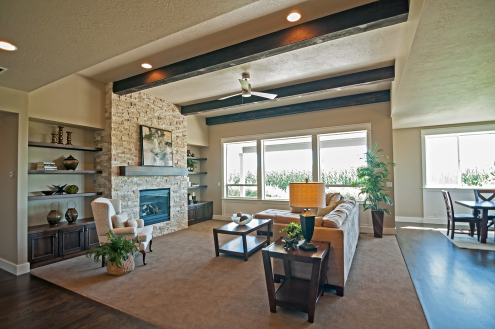 This is an example of a large classic open plan living room in Boise with grey walls, carpet, a standard fireplace, a tiled fireplace surround and a wall mounted tv.
