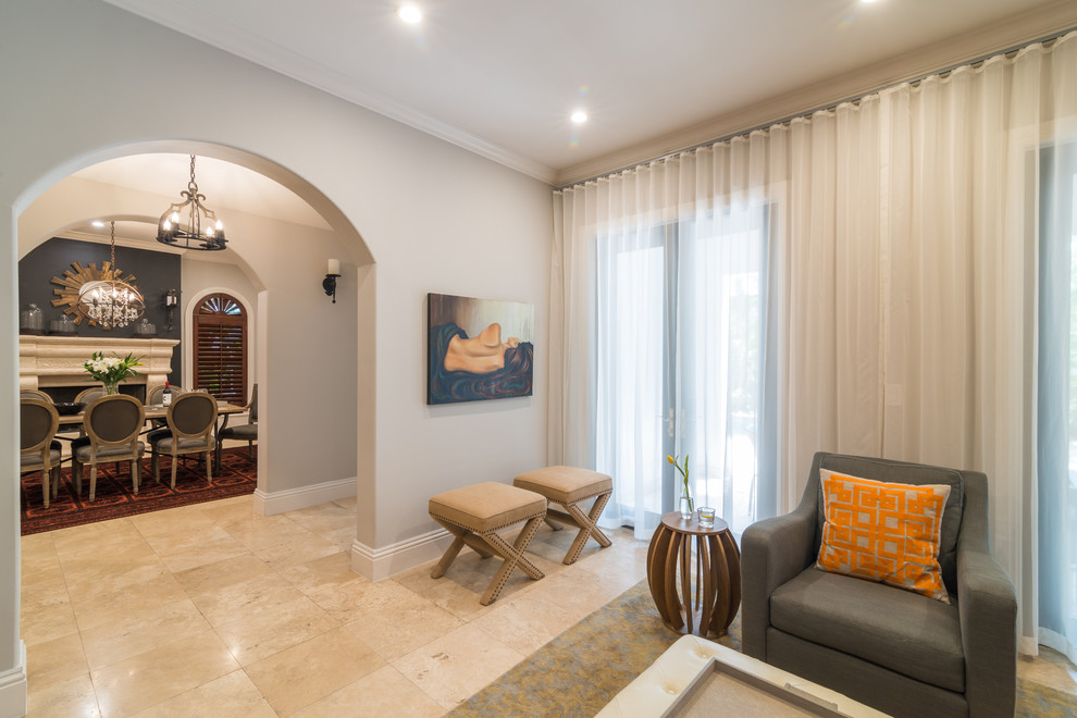 Идея дизайна: изолированная гостиная комната среднего размера в стиле неоклассика (современная классика) с серыми стенами, полом из травертина, стандартным камином и фасадом камина из камня
