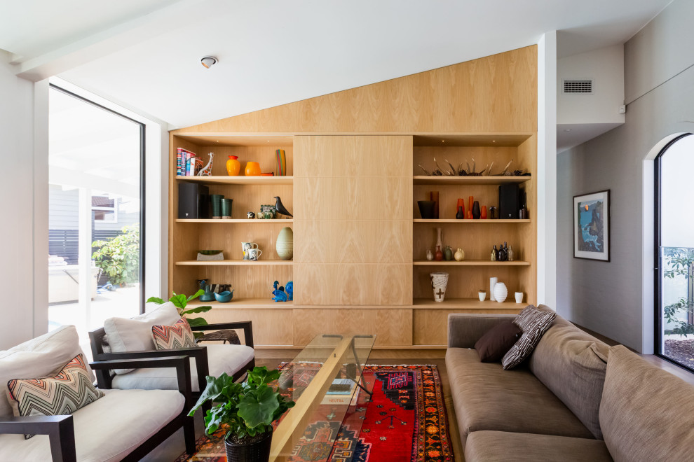 Foto di un soggiorno design aperto con pareti bianche, pavimento in legno massello medio, pavimento marrone e soffitto a volta