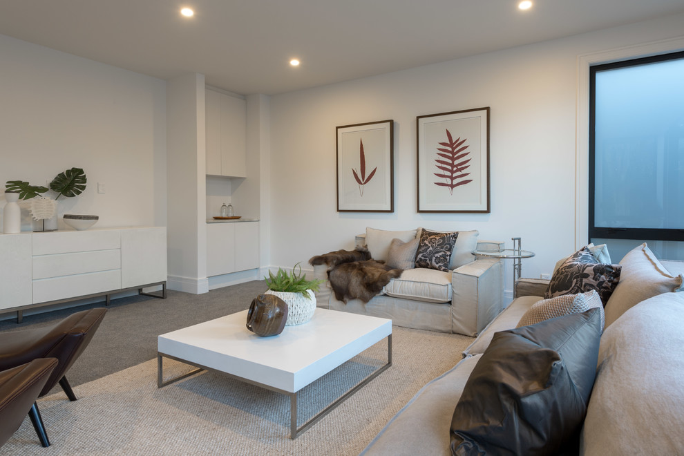 Mittelgroßes, Repräsentatives, Abgetrenntes Modernes Wohnzimmer mit weißer Wandfarbe, Teppichboden, Kamin, gefliester Kaminumrandung, Multimediawand und grauem Boden in Auckland