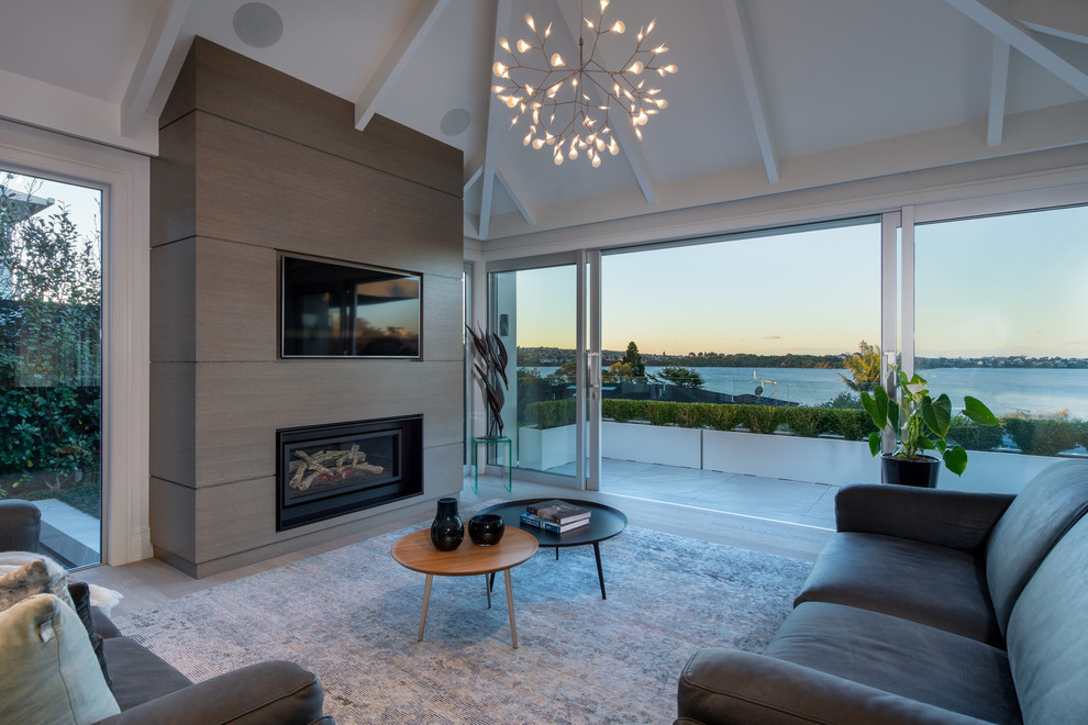 Inspiration for a large contemporary open concept and formal medium tone wood floor and brown floor living room remodel in Auckland with a ribbon fireplace and a wall-mounted tv