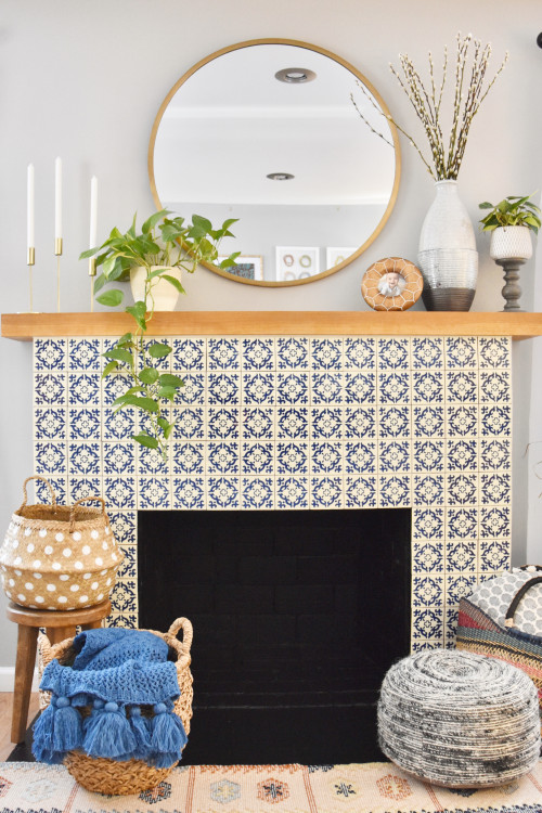 unique fireplace design with white and blue tiles, a round mirror and jute baskets