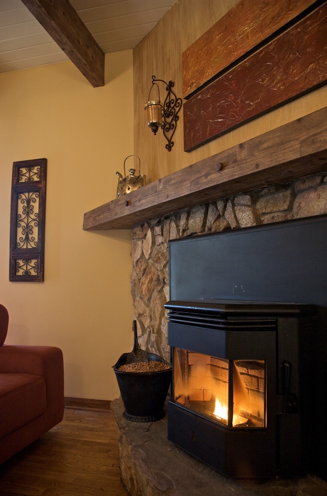 サンフランシスコにあるコンテンポラリースタイルのおしゃれなリビング (コーナー設置型暖炉、石材の暖炉まわり) の写真
