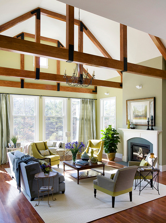 Example of a large classic formal and open concept medium tone wood floor living room design in Boston with green walls, a standard fireplace, a wood fireplace surround and no tv