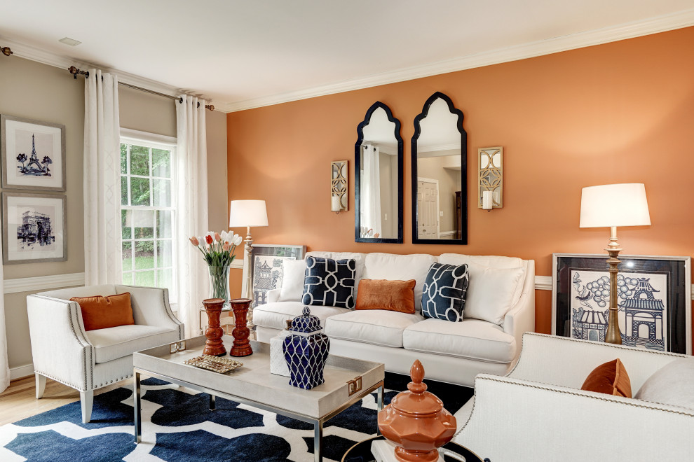 Стильный дизайн: гостиная комната в стиле неоклассика (современная классика) с оранжевыми стенами и паркетным полом среднего тона - последний тренд