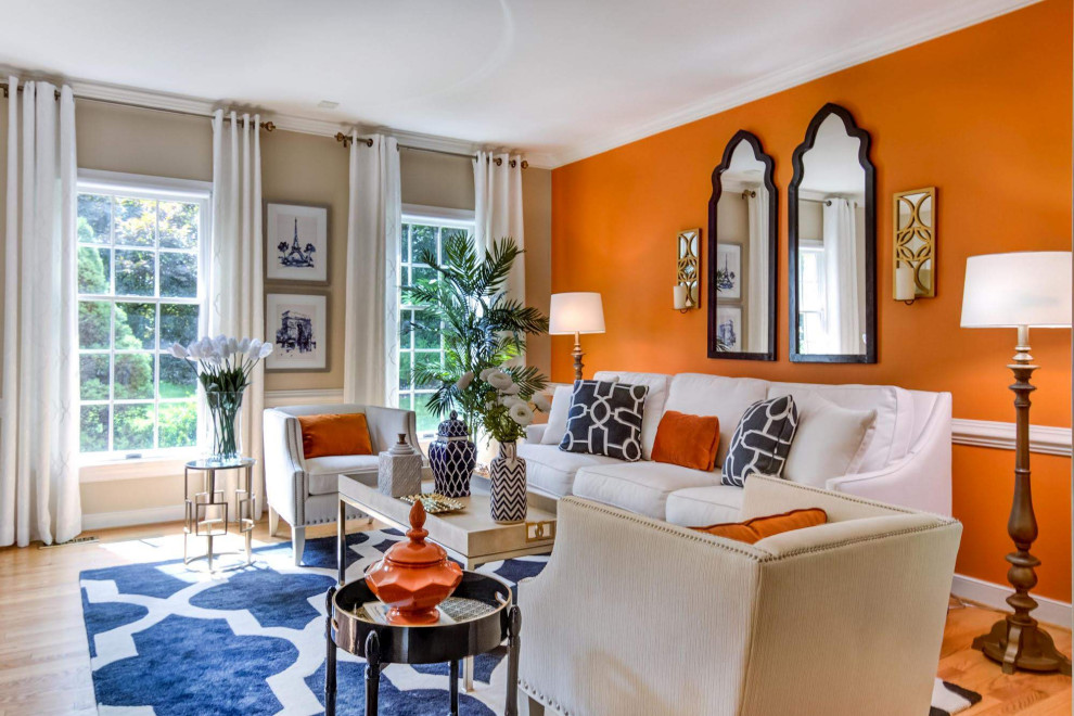 Idée de décoration pour un salon tradition avec un mur orange et un sol en bois brun.