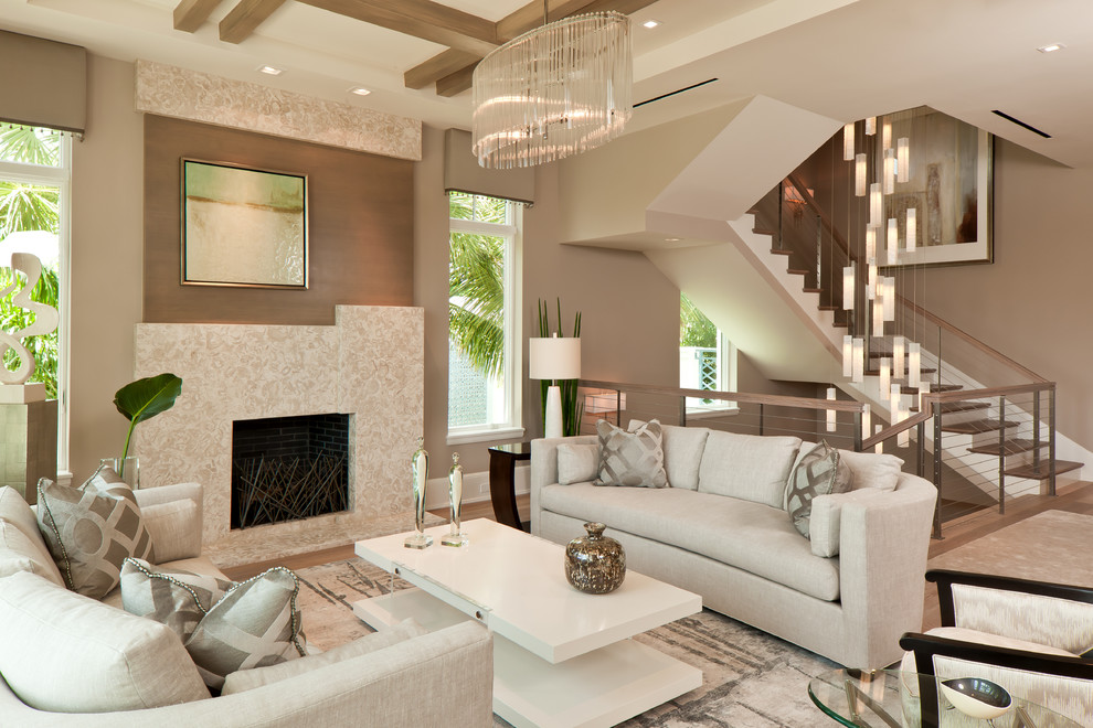 Cette image montre un salon design ouvert avec une salle de réception, un mur beige, une cheminée standard, un sol en bois brun et un manteau de cheminée en pierre.