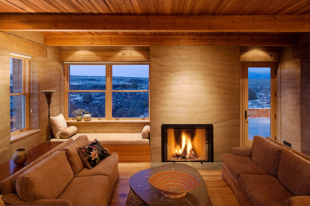サンフランシスコにあるサンタフェスタイルのおしゃれなリビング (標準型暖炉、茶色いソファ) の写真