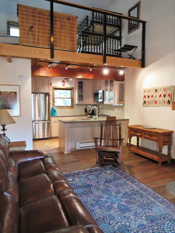 Großes Mediterranes Wohnzimmer im Loft-Stil mit beiger Wandfarbe, braunem Holzboden, Kamin, Kaminumrandung aus Stein und TV-Wand in Seattle