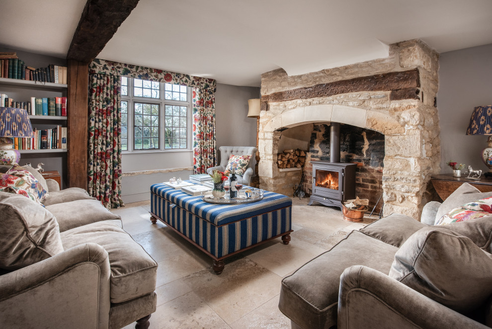 Großes, Repräsentatives, Abgetrenntes Wohnzimmer mit grauer Wandfarbe, Kalkstein, Kamin, Kaminumrandung aus Backstein und freigelegten Dachbalken in Oxfordshire