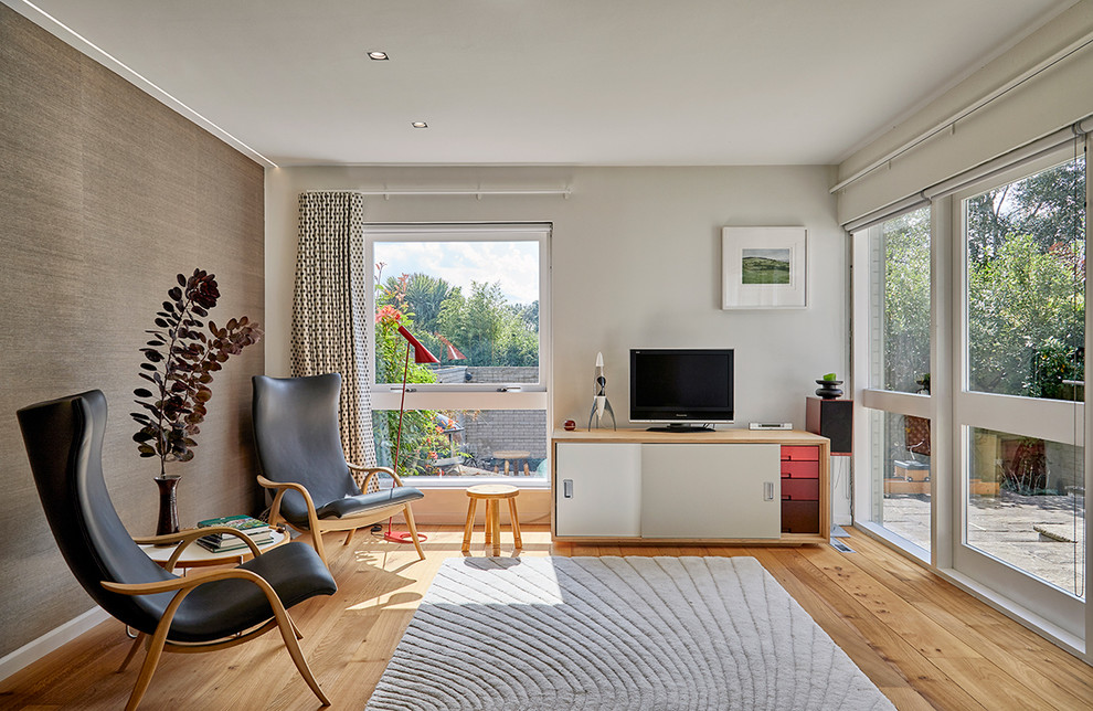 Foto di un soggiorno moderno di medie dimensioni e chiuso con pareti grigie, parquet chiaro, TV autoportante e pavimento marrone