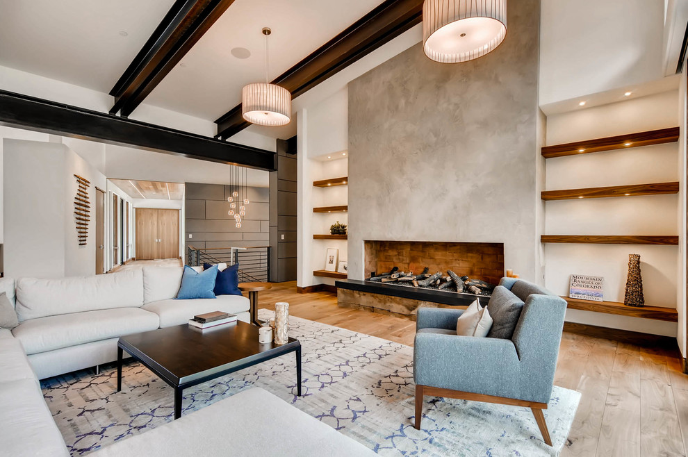 Идея дизайна: большая открытая гостиная комната в современном стиле с белыми стенами, паркетным полом среднего тона, стандартным камином, фасадом камина из бетона и коричневым полом