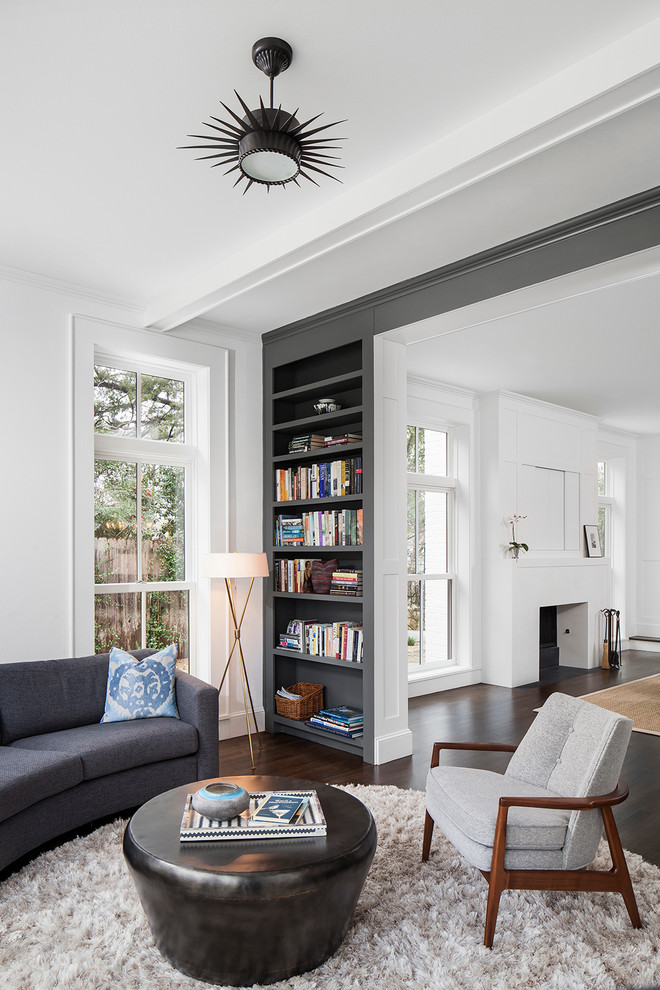 Großes, Abgetrenntes Klassisches Wohnzimmer mit weißer Wandfarbe, dunklem Holzboden, verputzter Kaminumrandung und braunem Boden in Austin