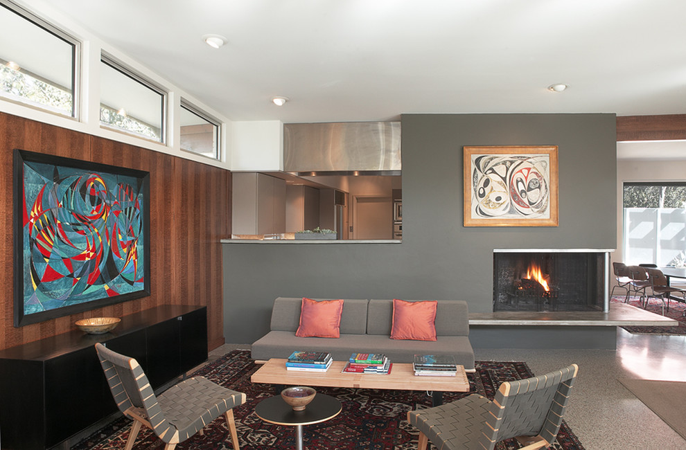 This is an example of a large retro formal open plan living room in Austin with grey walls, concrete flooring, a standard fireplace, a metal fireplace surround and no tv.