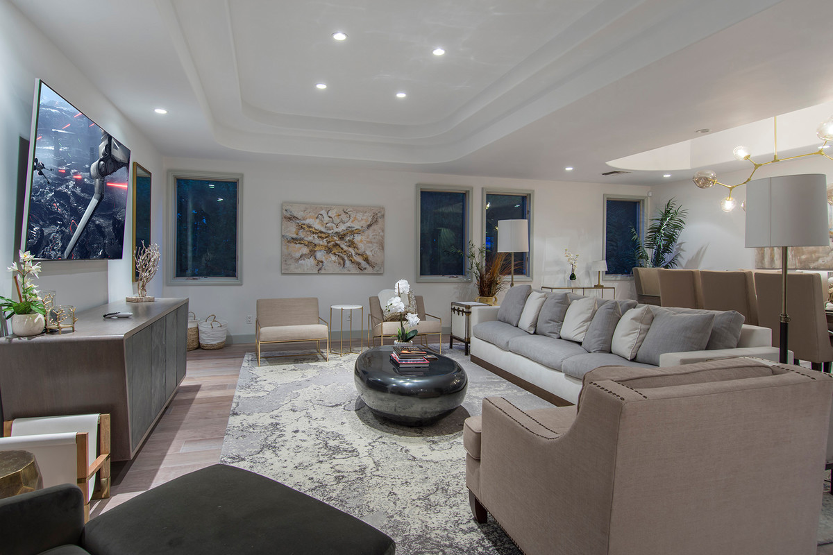 Medium sized contemporary formal and grey and cream open plan living room in Los Angeles with white walls, light hardwood flooring, no fireplace, a wall mounted tv and beige floors.