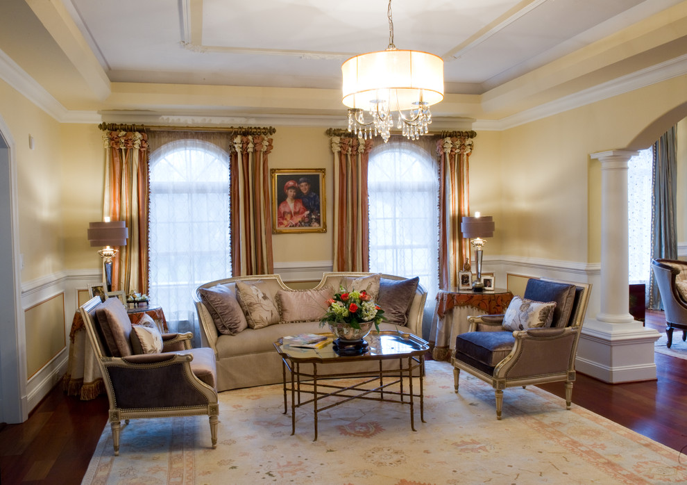 Imagen de salón para visitas abierto clásico renovado grande con paredes amarillas y suelo de madera en tonos medios