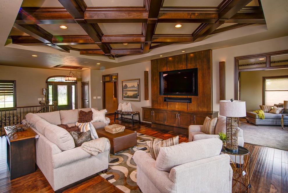 Diseño de salón tradicional sin chimenea con suelo de madera en tonos medios, pared multimedia y suelo marrón