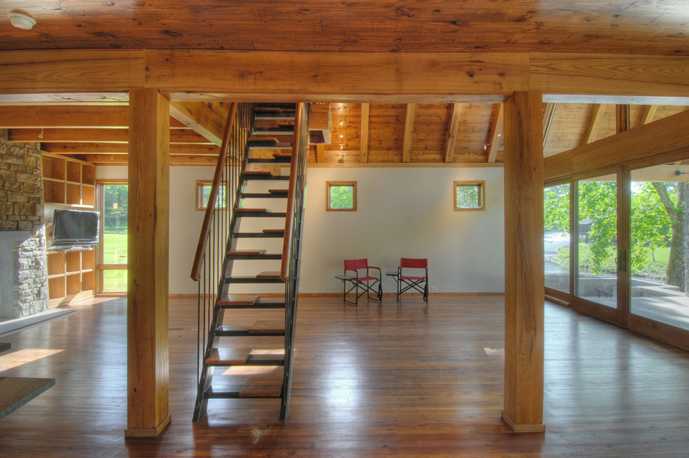 Esempio di un grande soggiorno stile rurale stile loft con pavimento in legno massello medio, camino classico e TV a parete